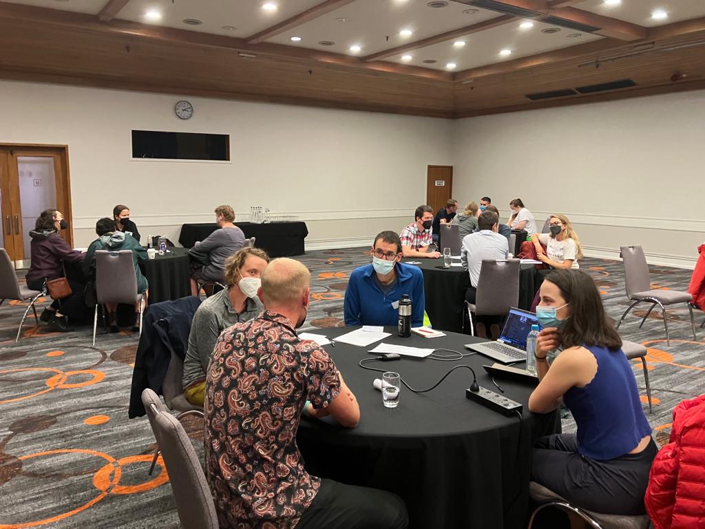 Attendees at the IAVCEI 2023 sit around a black table discussing career options.