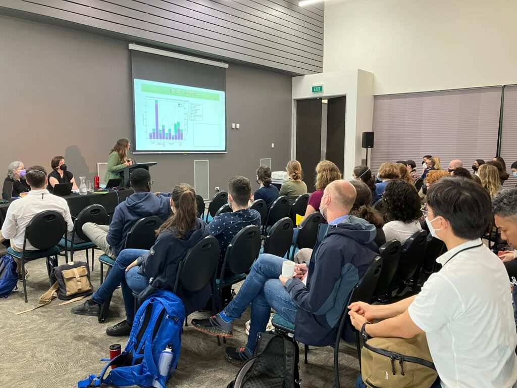 A scientist describes research presented onscreen to a roomful of volcanologists.